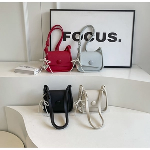 Litchi pattern saddle bags in four colors with pearl bow charms on display