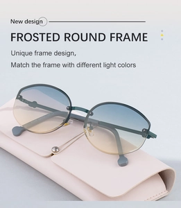Macro detail of frosted green round frames and gradient lenses with a pink leather case