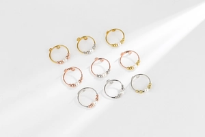 Set of 9 adjustable beaded rings in gold, silver, and rose gold with white faux pearls