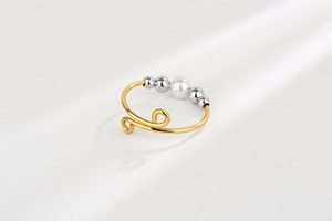 Detail of spiral open ring with central pearl and four silver beads for anxiety relief