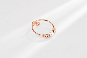 Detailed macro view of an adjustable fidget ring featuring beads and a white pearl accent