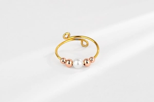 Detail view of adjustable ring with white pearl and rose gold beads for stress relief