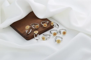 Collection of sunflower rings with gold plating and zircons on white fabric