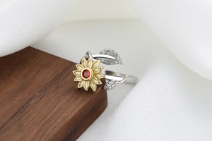 Detailed view of bicolor sunflower ring with ruby red center on silk fabric