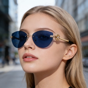 Détail de lunettes de soleil bleues sans monture avec charnière fleurie dorée et strass