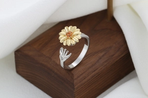 Macro detail of sunflower spinner ring with golden petals and adjustable silver band