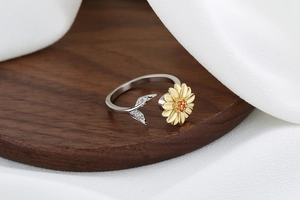 Macro shot of silver rotating ring with a gold sunflower and sparkling orange crystals
