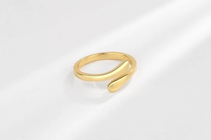 Makroaufnahme des hochglanzpolierten goldenen offenen Rings mit minimalistischem Design