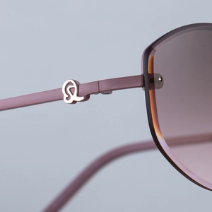 Macro shot of stylish rimless sunglasses showing lavender frame and rose gold logo
