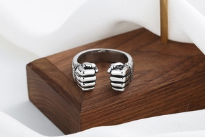 Detail of silver fist ring with vintage oxidized finish on rustic wood stand