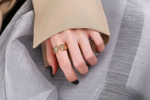 Close-up of golden power fist ring with textured segments worn by a male model