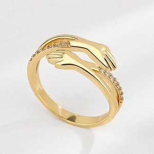 Minimalistischer goldener Umarmungsring mit Zirkonia-Steinen auf weißem Hintergrund