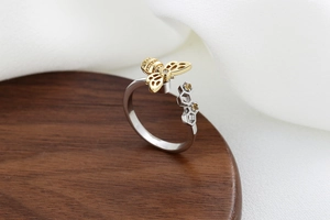 Macro shot of silver bee ring with honeycomb pattern and yellow stones on wooden stand