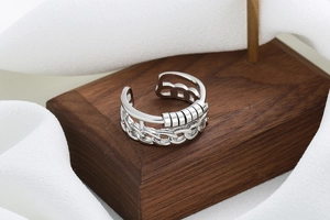 Detailed macro view of rotatable cylinder beads on a Cuban chain style anxiety relief ring
