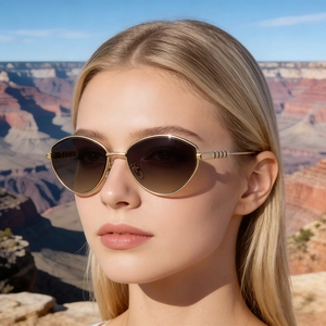 Occhiali da sole cat-eye alla moda con montatura dorata e lenti marroni sfumate