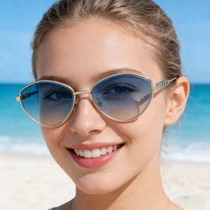 Dettaglio occhiali da sole cat-eye con montatura in metallo dorato e lenti blu sfumate