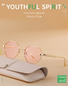 Close-up of octagonal metal sunglasses with pink lenses and a leather storage pouch