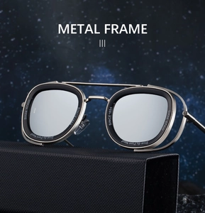 Detail view of oval metal frame sunglasses with side shields on a black textured box