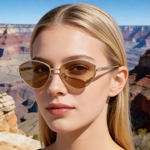 Dettaglio occhiali da sole cat-eye dorati con lenti sfumate marroni sulla modella