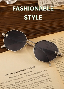 Detailed close-up of polygon metal sunglasses resting on a vintage book on a wooden surface