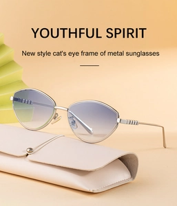 Dettaglio degli occhiali da sole cat-eye in metallo su una custodia in pelle beige