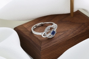 Macro shot of silver orbital planet ring with blue star stone and paved diamonds