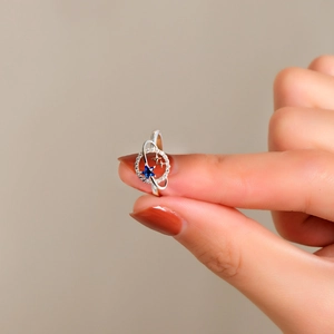 Macro shot of silver Saturn planet ring featuring a blue star stone and small diamonds