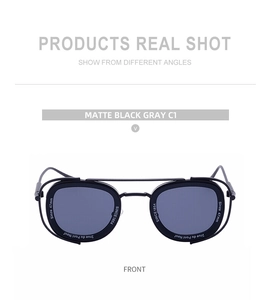 Detail of matte black double-bridge sunglasses with gray lenses and white lens text