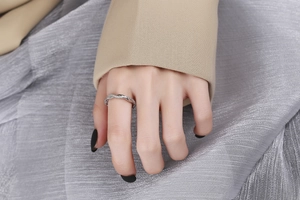 Dettaglio anello intrecciato in argento con cristalli pavé indossato da una modella