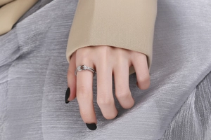 Dettaglio di un anello a nodo in argento con zirconi scintillanti sulla mano di una modella
