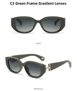 Detail view of olive green cat-eye sunglasses with silver H-shaped metal hinge and gradient lenses