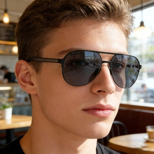 Close-up of classic black pilot sunglasses with polarized lenses on male model