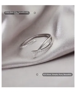 Detailopname van een 925 zilveren gekruiste ring met kleine zirkonia op grijze zijde