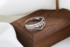 Macro detail of silver multi-layer crossover ring featuring a kinetic spinning metal bead