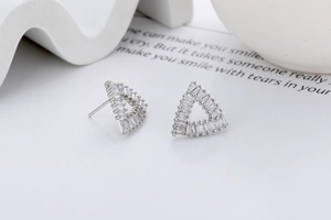 Macro shot of silver triangle stud earrings with inlaid baguette-cut cubic zirconia