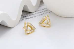 Macro side view of hollow triangle earrings in gold with clear zircon stones