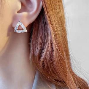 Vintage geometric triangle earrings with zircon inlay shown on model ear in gold finish
