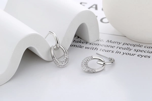 Detail of silver double hoop earrings with cubic zirconia on a white display