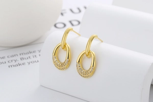 Detail of gold oval earrings with double loops and shimmering pavé white zircons
