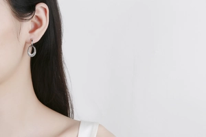 Close-up of silver-tone double loop drop earrings with sparkling pavé zircons on model