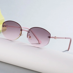 Chic rimless sunglasses with pink gradient lenses and gold accents on a white stand