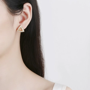 Minimalist golden triangle stud earrings with inlaid cubic zirconia on a female model