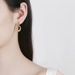 Elegant gold double hoop pearl earrings with pavé stones on a model in profile view