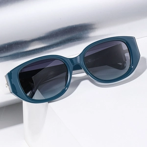 Deep green cat-eye polarized sunglasses for women with gray gradient lenses on a pedestal
