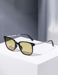 Detail of folding hinges on black square sunglasses with yellow lenses and metal joints