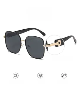 Détail de lunettes de soleil carrées polarisées avec charnière en alliage doré