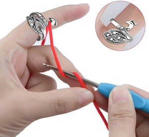 Detail of adjustable peacock knitting ring showing yarn tension guide for crochet