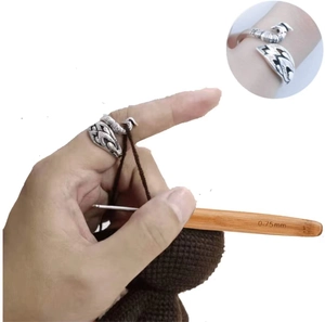 Close-up of vintage peacock knitting ring guiding yarn during crochet work