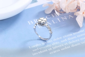 Close-up of silver four-leaf clover ring with rotating top and hollow chain band design