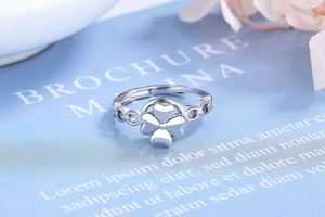 Detailed close-up of a rotating silver four-leaf clover ring with chain-style band